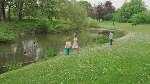 happy family. Three kids run legs near Lake go fishing. people in the park concept. Boy son girl Siblings together joyful summer. little Toddler Child running smilling kid dream concept lifestyle