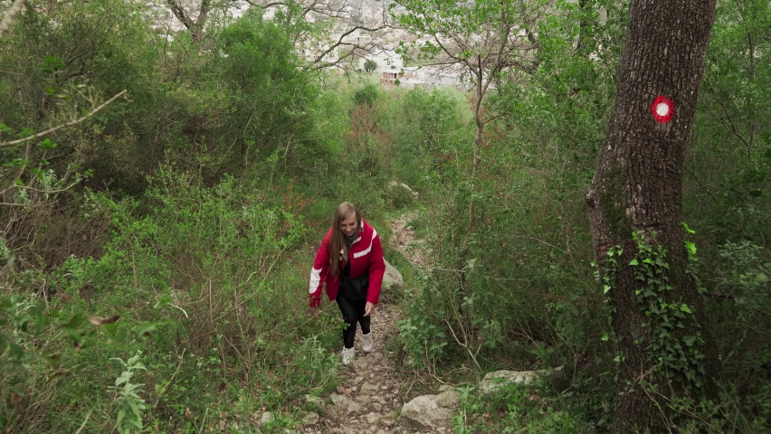 A young girl walks in the mountains of Montenegro. Rise along the mountain path to the ruined fortress. Fortress in Sutomore Montenegro. Rest in the mountains of Montenegro. Hiking in the mountains.