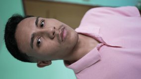 Portrait of a hispanic man looking at camera. A serious young latin person person in vertical video
