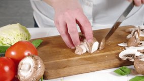 Close-up video of cutting slicing fresh mushrooms. Womans hands cut with knife fresh mushroom vegetables