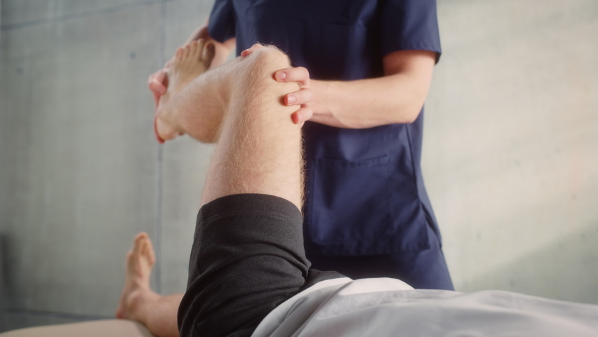 Close Up of a Sportsman Patient Undergoing Physical Therapy to Recover from Surgery and Increase Mobility. Physiotherapist Works on Specific Muscle Groups or Joints to Rehabilitate from Injury. | Shutterstock HD Video #1090756293