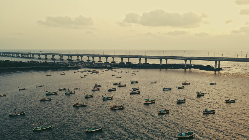 Aerial evening view of fishing boats sailing near Bandra Worli Sea Link in Mumbai, India. Sunset skyline in Mumbai. Weather in Bombay.