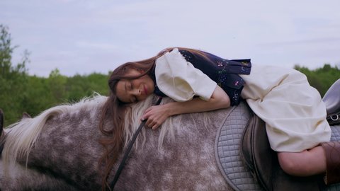 The girl is lying on a horse. Woman riding a horse. Hugs the horse. Ukraine
