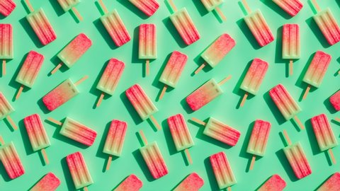 Vibrant, multicolored popsicles on a rainbow background. Frozen snack on a stick perfect for summer refreshment during hot days. Seamless looping animation of ice pops. Homemade watermelon flavour