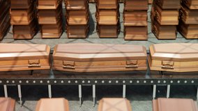 An endless looping video of coffins moving on a conveyor belt at the airport. Transportation system for bodies of deceased people. Funeral, memorial service transport. Wooden coffins stacked.