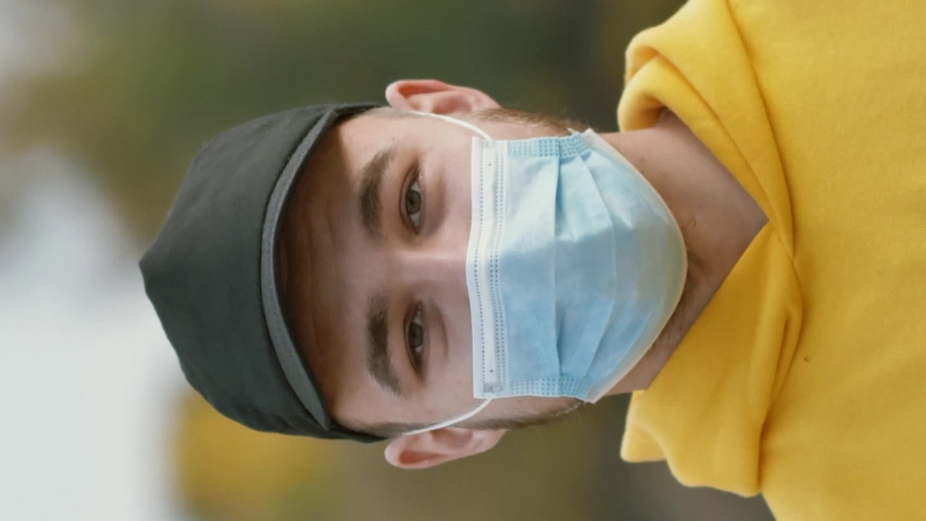 A portrait of a young man in a protective mask nods his head approvingly in the street. Health and safety concept, N1H1 coronavirus, COVID-19 infection, virus protection, pandemic