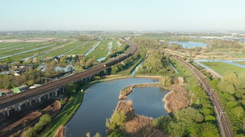 NS Intercity Train On The Railway Passing By Polder In Gouda, Netherlands. aerial