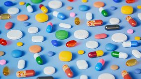 Countless multi-colored pills, capsules and tablets scattered on a light blue ground. Seamless looping video with colorful drugs. Perfect background for medicine, pharmacy or healthcare topics.