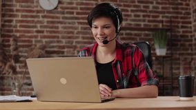 Young smiling woman using laptop and wireless headset for online meeting, video call, video conference. Communication online with colleagues,relatives,friends.Freelance,remote working,online education