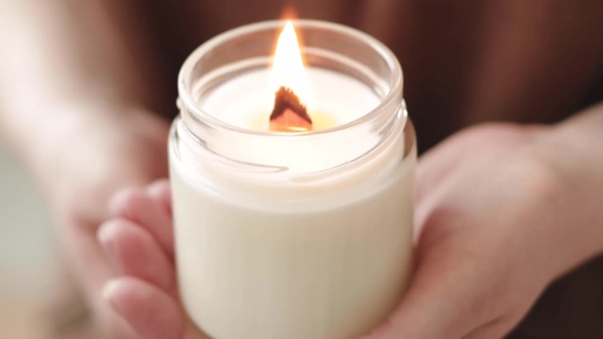 Close-up cropped shot of unrecognizable young woman lighting handmade aroma candle holding in hand. Royalty-Free Stock Footage #1090766681