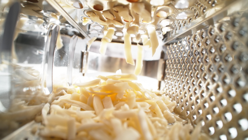 Grated Cheese Strips Falling into the Cheese Grater - View from Inside of the Kitchen Utensil Royalty-Free Stock Footage #1090771159