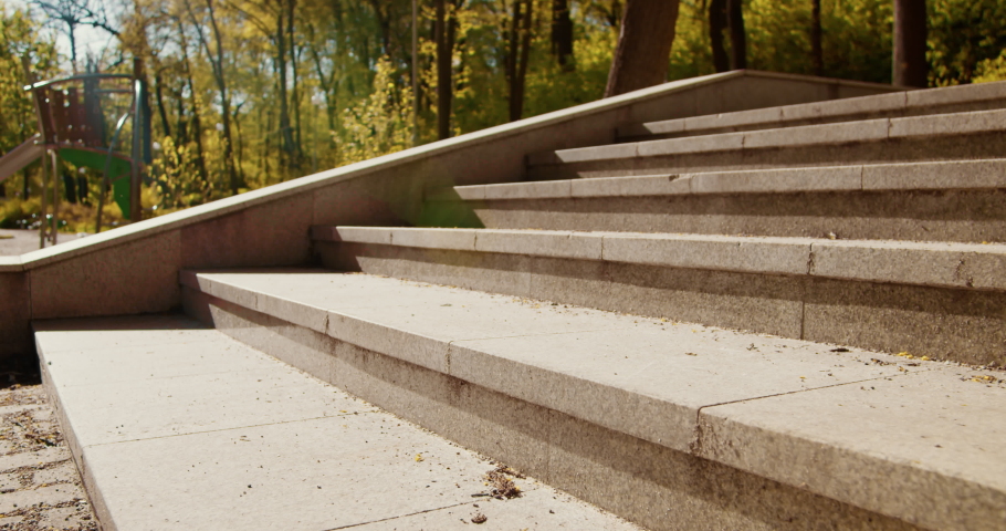 Young woman runs up the stairs in the park. Active female outdoors in summer morning