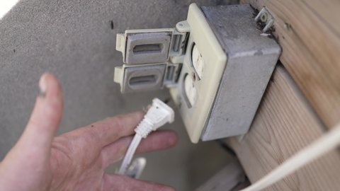 Getting electrocuted after plugging a cable into an exterior electricity outlet.