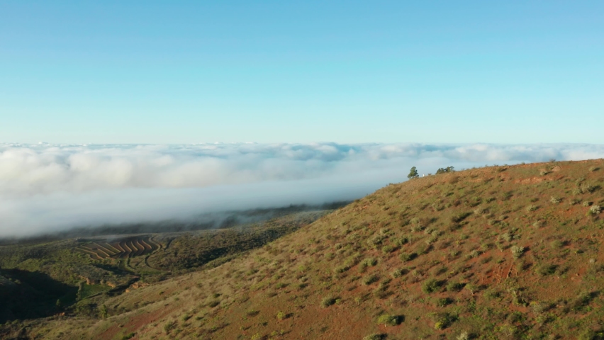 4K drone aerial shot of dream house in the clouds, Montana del Pozo, farms and fields during sunrise above clouds near Vilaflor - Tenerife, Canary Islands
