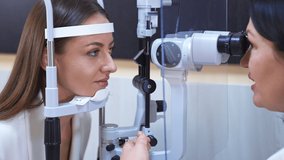 Attractive long-haired woman at optician's check up. Doctor uses special equipment to check the eyesight of a patient. - Powered by Shutterstock - Get 15% off with code: PIKWIZARD15