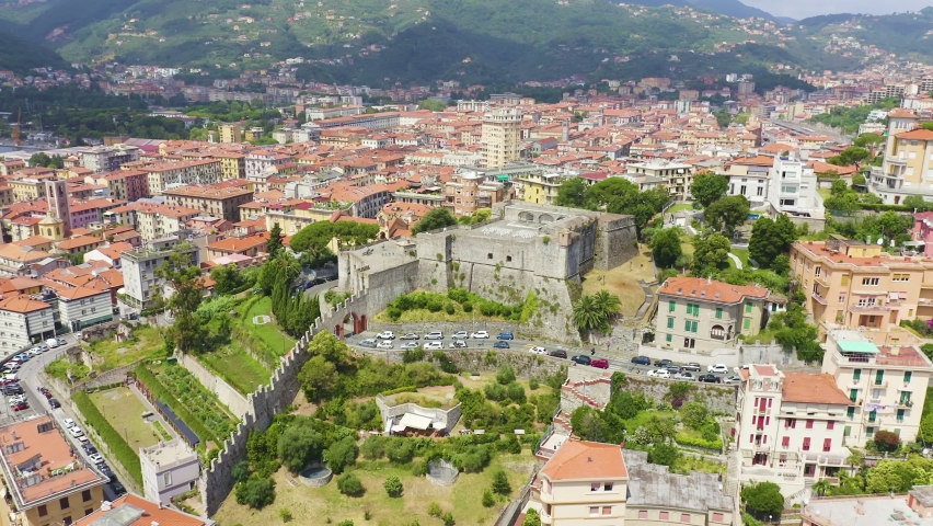 Inscription on video. La Spezia, Italy. Castle of San Giorgio. View from above. Multicolored text appears and disappears, Aerial View