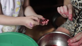 Women's hands peel cherries from the pits. Cherries are cleaned for jam, a woman takes out the seeds from the cherries.