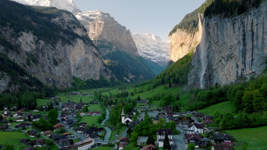 flying in Lauterbrunnen valley in Switzerland, famous Swiss alpine village landscape with Staubbach waterfall at sunrise, pictiresque aerial view of Lauterbrunnen valley. High quality 4k footage Royalty-Free Stock Footage #1090786489