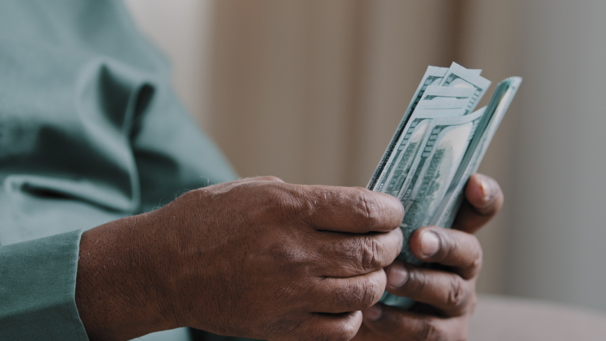 Close-up old male African American hands counting money dollars indoors. Unrecognizable senior mature man calculating cash financial savings family budget pension payments at home high income loan Royalty-Free Stock Footage #1090787081