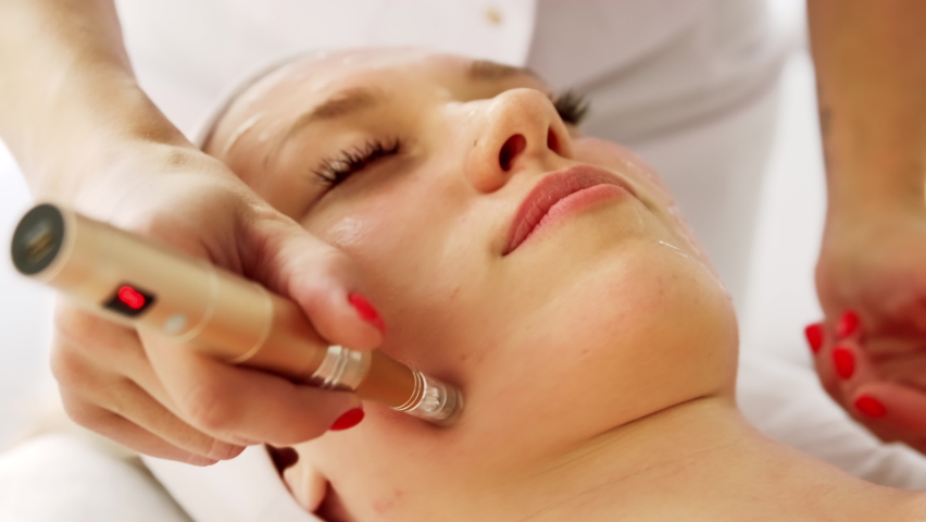 Beautician cosmetologist doing procedure fractional microneedle mesotherapy with Dermapen. Hardware cosmetology in clinic salon for client.  | Shutterstock HD Video #1090790041