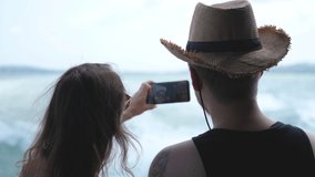 Couple having fun taking selfie video using smart phone on cruise ship, Multicultural couple smilng having fun laughing on travel vacation.