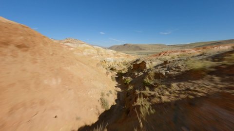 Aerial view speed movement cracked dry rocky geology formation texture wilderness nature mountain landscape. FPV sports drone shot fast flight over cliff canyon desert hilly terrain natural park area