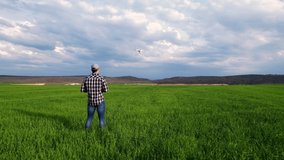 Young farmer flying a drone over a field. High quality 4k footage