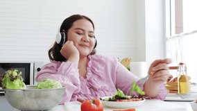 Happy overweight woman eating and enjoying fresh salad. healthy food