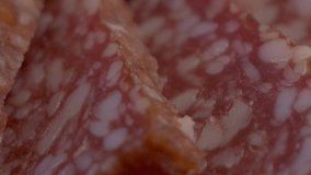 A few pieces of salami sausage taken in close-up. Meat appetizer, sliding shot