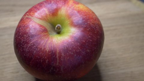 One large ripe gala apple in close-up. Video with rotating apple.