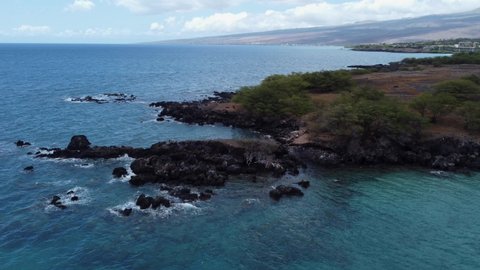 4K cinematic clockwise drone shot of waves crashing onto lava rock at Waialea Beach (Beach 69) near Kona. This Big Island of Hawaii coastline was filmed using a DJI Mini 2 drone.