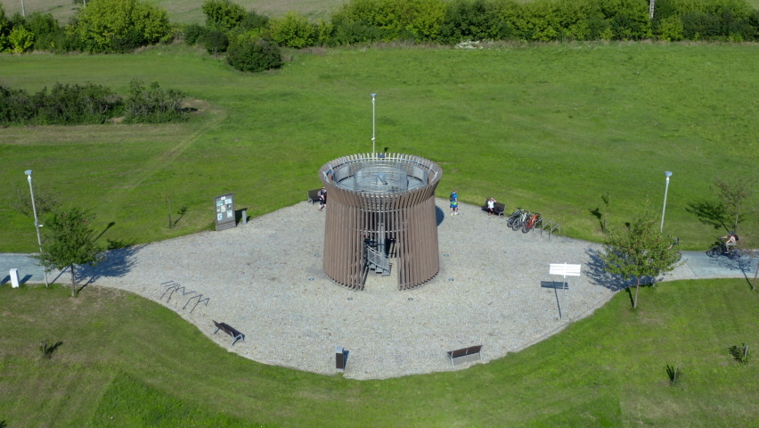 Couple cycling around lookout tower in Lednice park,drone shot.