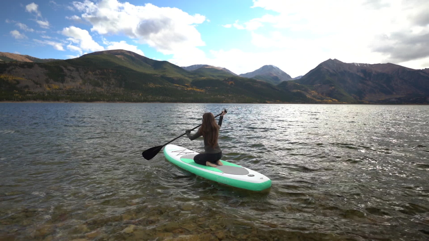 Back View of Young Woman Paddling on Lake on Rubber Paddle Board, Slow Motion. Twin Lakes, Colorado USA