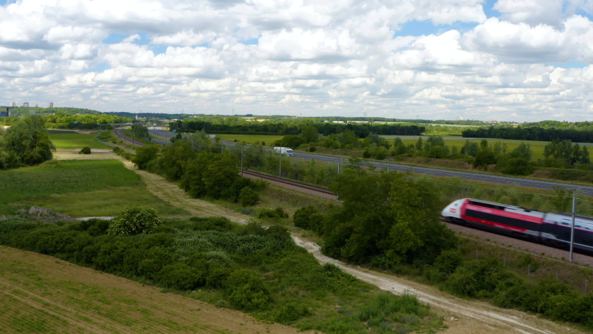 Country travel by high-speed train. Aerial view of fast passenger train driving on railroad. High angle view of Passing highspeed train in rural summer country landscape. 