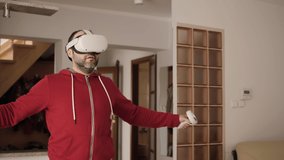 Man on Virtual Reality Glasses Doing Variation of Online Fitness Training. Man Wearing Virtual Reality Headset Holding Gaming Controllers. Sportsman in VR Headset Working Out at Home. Metaverse Oculus