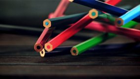 Colored pencils fall on a wooden table. Against a dark background. Filmed is slow motion 1000 fps. - Powered by Shutterstock - Get 15% off with code: PIKWIZARD15