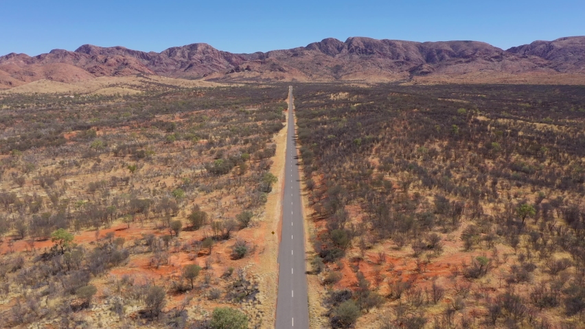 Desert road aerial in Australia outback near West MacDonnell National Park, Alice Springs, Northern Territory Royalty-Free Stock Footage #1090820589