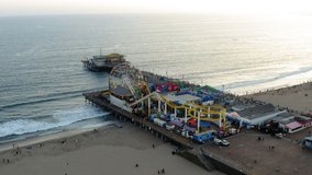 Aerial drone footage of Pacific Park pier during sunset in Santa Monica, CA.