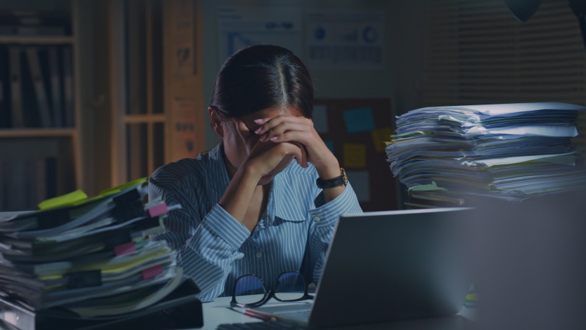 Young Asian office employee feeling tired, fatigue, exhausted while working overtime at night in office Royalty-Free Stock Footage #1090824769