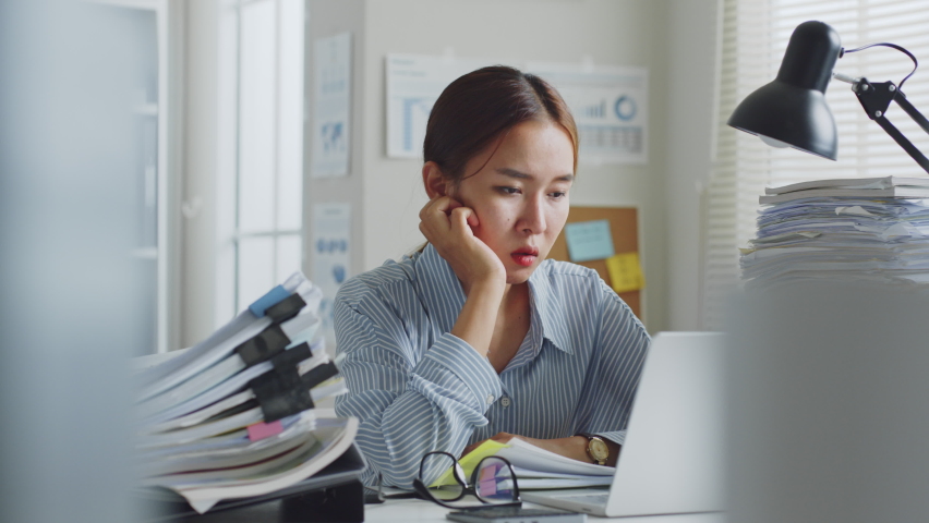 Tried young Asian office employee feeling sick and have a headache from a long working day at office | Shutterstock HD Video #1090824771