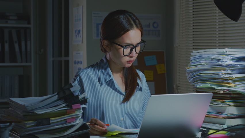 Timelapse of Asian office employee wearing eyeglasses working  busy, work hard, overtime, at night in office Royalty-Free Stock Footage #1090824775