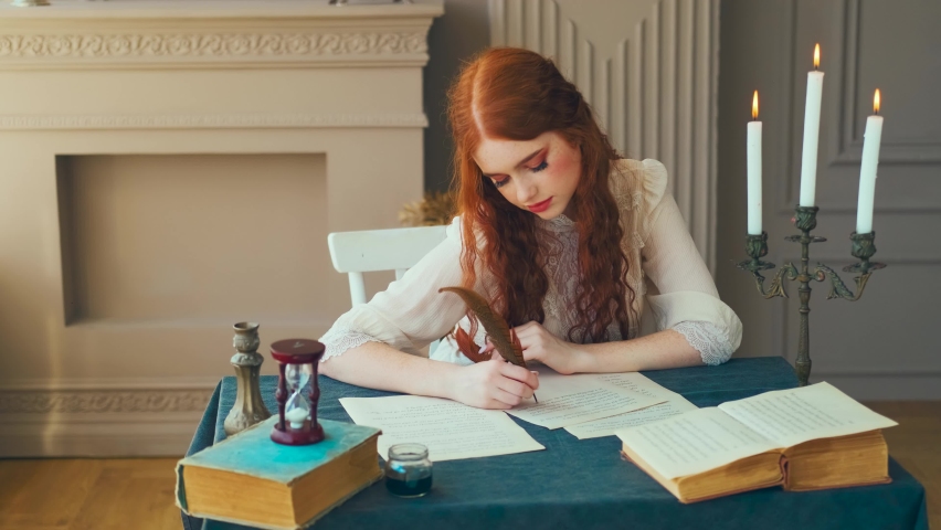 Medieval red-haired woman writer holds pen feather quill in hands, sits at table writes letter on sheet paper. Vintage dress ancient room antique candlestick, old books. Girl smiling student studying. Royalty-Free Stock Footage #1090825437