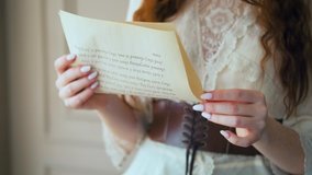 Red-haired fantasy business woman portrait close-up holds documents in hands face cropped. Medieval girl princess reads love letter. Vintage dress long red hair, brown suit white blouse, old room. 4k