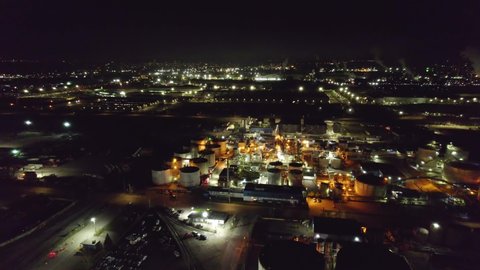 Industrial oil and gas manufacturing refinery factory at night, petrol crude and petrochemical plants in America, modern factory lightning in pitch black night