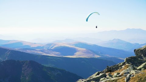 Paraglider take off and flight in breathtaking mountains.
Paraglide flight lesson and the jump and take off from hill of high mountain peak in scenic mountain range -perfect active holiday destination