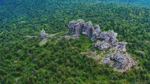 Rocks in the mountains in the middle of a dense green forest. Beautiful natural landscape. Aerial view