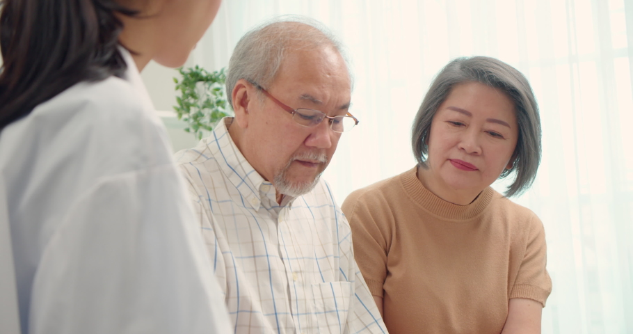 Elderly man was worried as he listened to the doctor explain his diagnosis with sat on the living room sofa at home.His wife sat nearby provide psychological support.The patient's mood looked gloomy. Royalty-Free Stock Footage #1090838711