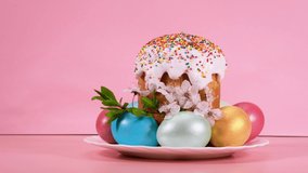 Video motion decorative composition of Easter cake, eggs, cherry blossom branches on a pink background. 4k