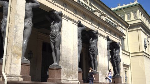 Atlanteans in the Hermitage support a massive balcony. Russia, Saint Petersburg June 2021