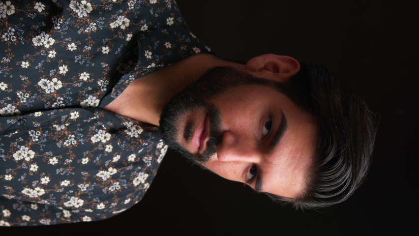 hair commercial concept. vertical studio shot of a handsome cuban bearded black-haired man in his 30s looking at camera and touching his hair in a seductive manner. High quality 4k footage Royalty-Free Stock Footage #1090845759
